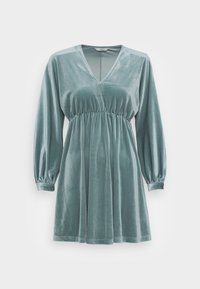 Sametové šaty v modrozelené barvě s hlubokým výstřihem do V, dlouhými balónovými rukávy a elastickým pasem, s volnou sukní a jemnou texturou.