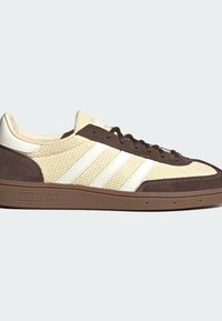 Κορυφαίο sneaker Adidas σε μπεζ πλεκτό με καφέ σουέντ επενδύσεις, λευκές δερμάτινες ρίγες και καφέ υφή λαστιχένιας σόλας.