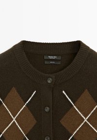 Cardigan en laine brun foncé avec fermeture à boutons et motif losanges argyle comprenant des losanges marron et des lignes diagonales blanches.