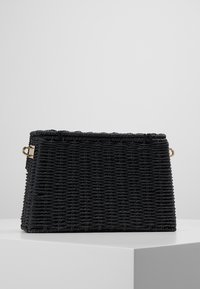 Borsa intrecciata nera con forma strutturata. Presenta una texture liscia, una cucitura superiore e hardware in tonalità oro per l'attacco.