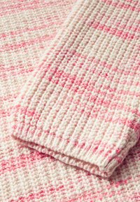 Tessuto tessuto con una base crema e strisce rosa alternate, morbida texture e un bordo piegato che mette in evidenza un motivo di tessitura più spesso.