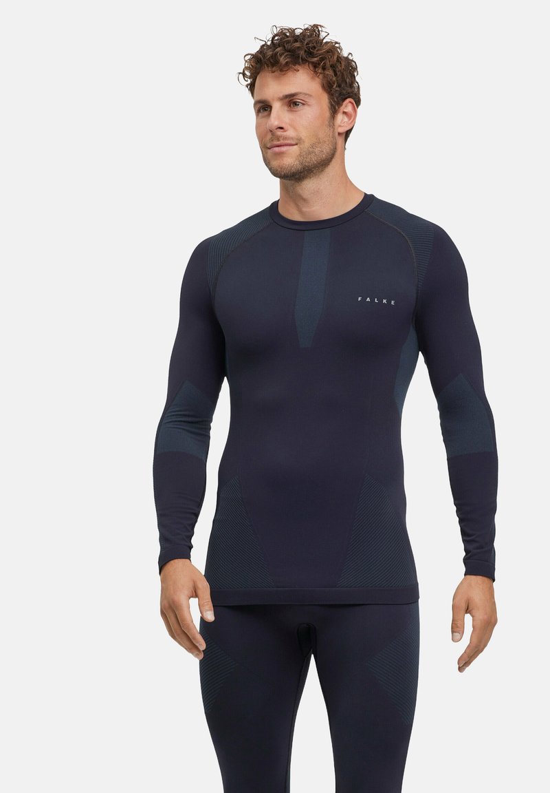 Haut actif à manches longues bleu marine avec des panneaux texturés et une coupe ajustée. Il présente un col rond et un logo subtil sur la poitrine.