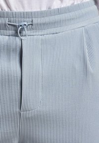  lichtblauwe corduroy joggers met een ribbelstructuur, voorzien van een trekkoord in de taille en zijzakken voor gemak.
