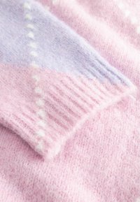 Strickpullover in sanftem Pastellpink mit Akzenten in Flieder; verfügt über gerippte Bündchen und eine strukturierte Oberfläche mit einem subtilen gepunkteten Muster.