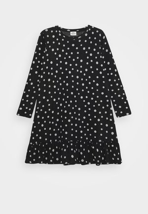 Robe noire à manches longues avec des pois blancs et un ourlet volanté.