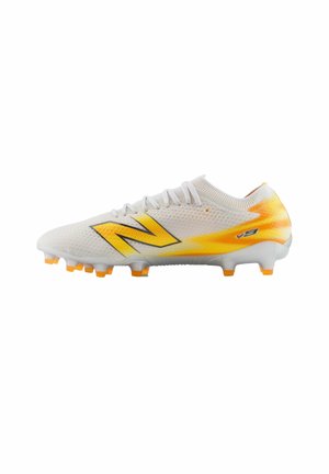 White and yellow soccer cleat with lace-up design and orange-tipped studs, featuring a large yellow logo on the side.