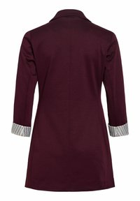 Sacou lung bordo cu mâneci trei sferturi, manșete întoarse care arată o țesătură albă cu dungi subțiri negre.