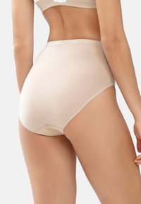 Hochtaillierte, hautfarbene Baumwollslips mit glatter Textur, einem elastischen Bund mit Markenlogo und nahtlosen Kanten für hohen Tragekomfort.