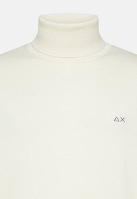 Maglione a collo alto bianco realizzato in tessuto morbido, con un design aderente e un piccolo logo ricamato sul lato sinistro del petto.