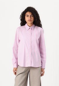 Light pink button-up shirt with blue and purple vertical stripes, long sleeves, and a pointed collar; smooth fabric, relaxed fit.