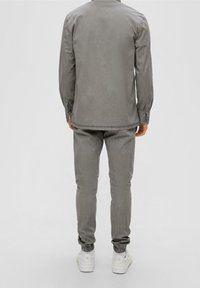 Grijze casual set van overhemd en broek, gemaakt van katoen, met lange mouwen, elastische manchetten en een gladde structuur. Geschikt voor ontspannen dragen.