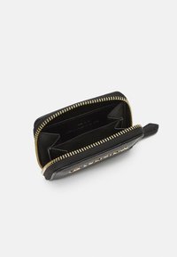 Portefeuille en cuir noir avec zip doré, comportant deux compartiments, dont un avec des emplacements pour cartes. Extérieur texturé pour une meilleure prise en main et durabilité.