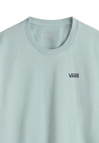 Světle modré tričko s krátkým rukávem vyrobené z bavlny, s kulatým výstřihem a černým logem "VANS" na levé části hrudi.
