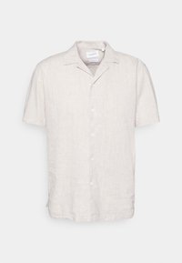 Chemise en lin à manches courtes de couleur beige clair, dotée d'un col et d'une patte de boutonnage, avec une finition texturée et des fentes latérales pour faciliter les mouvements.