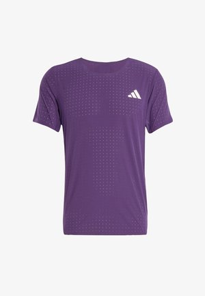 Lilla treningstrøye med korte ermer, med et prikkete mønster over hele overflaten og en hvit Adidas-logo på venstre brystområde.