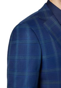 Granatowa marynarka w kratę z subtelnymi zielonymi akcentami, z wyraźnie zarysowanymi ramionami i gładką teksturą, wykonana z lekkiego materiału.