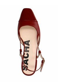 Rode leren slingback hak met een vierkante neus, voorzien van een dunne enkelband en een contrasterende beige binnenzool met daarop de opdruk 'SACHA'.