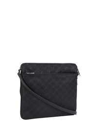 Svart axelväska av texturerad nylon, med geometriskt mönster, en övre dragkedjestängning och ett justerbart band.