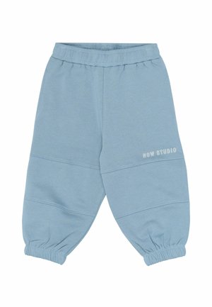Pantalon de jogging bleu clair pour tout-petit avec ceinture et poignets élastiques, avec le texte « NOW STUDIO » sur la cuisse droite.