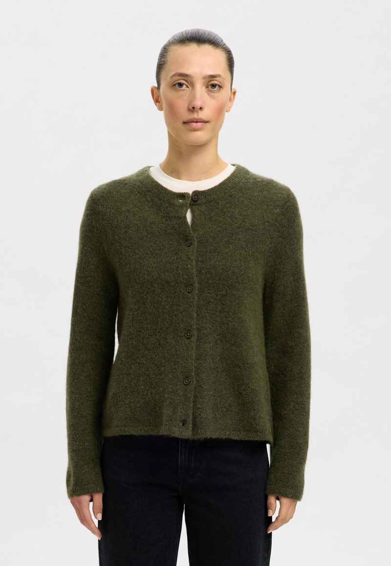 Grønn ullcardigan med rund hals, knappelukking foran, lange ermer og en myk, teksturert finish. Litt kortere i midjen.