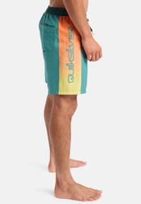 Plavky s gradientním designem v barvách modré, oranžové a žluté s logem "Quiksilver" v modré na boku a elastickým pasem.