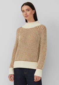 Strickpullover mit hohem Kragen, der ein braun-creamfarbenes Zickzackmuster, gerippte Säume und Bündchen sowie einen lockeren Schnitt bietet.
