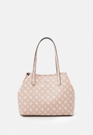 Sac fourre-tout beige Guess avec motif monogramme blanc, deux bretelles d'épaule, et logo centré près du haut.