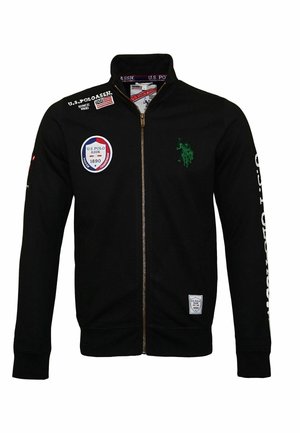 Czarna kurtka na zamek z logo U.S. Polo Assn., w tym zielonym emblematem gracza polo oraz naszywkami z tekstem na piersi i prawym rękawie.
