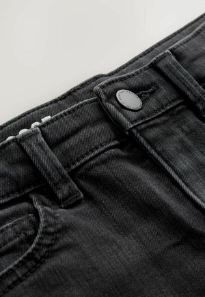 Black denim jeans featuring a textured surface, top button, and belt loops. The fabric has a smooth, slight sheen.
