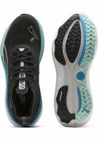 Zwarte sportschoenen met een getextureerde mesh bovenkant, blauwe en witte accenten en een rubberen zool met een multidirectioneel profiel.