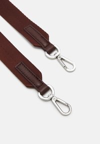 Bruine geweven stoffen band met leren accenten en zilverkleurige metalen klemmen aan beide uiteinden. Kenmerkt zich door een textuur en duurzame constructie.