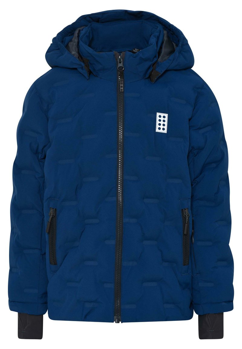 Veste rembourrée bleu marine avec fermeture éclair à l'avant, capuche et deux poches latérales zippées ; présente un design à panneaux texturés et un logo sur la poitrine.