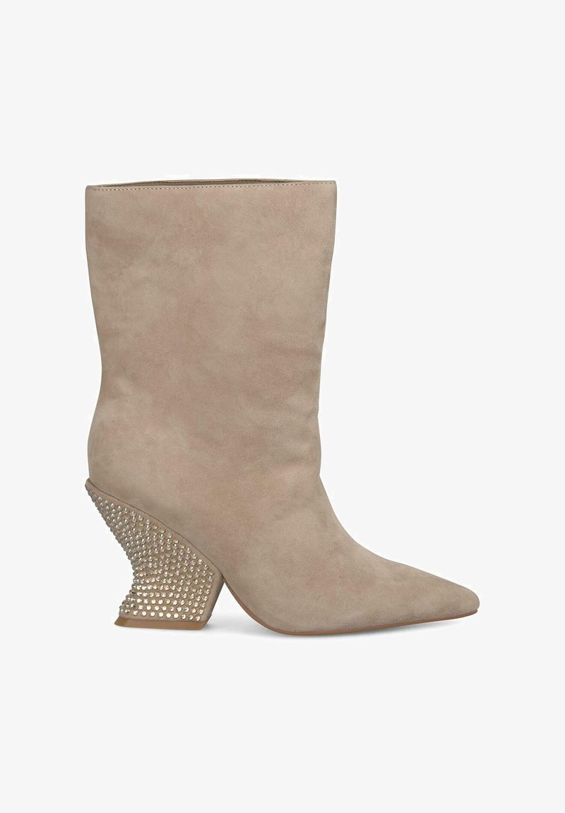 Beige suède enkellaars met een puntige neus en een getextureerde, met studs versierde hak die naar buiten toe uitloopt, met een gladde, strakke afwerking.
