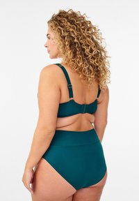 Türkisfarbenes Bikini-Set mit verstellbaren Trägern, hoch geschnittenem Slip und glattem Stoff. Die Rückansicht zeigt den Verschluss und nahtlose Designdetails.