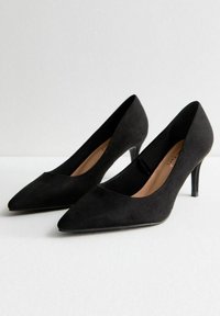 Décolleté nere in suede con punta affusolata e silhouette elegante, dotate di una morbida fodera interna e tacchi a stiletto sottili.