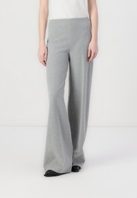 Gray flared trousers made from soft fabric, featuring a wide-leg design and a smooth, stretchy waistband. Black shoes complement the outfit.
