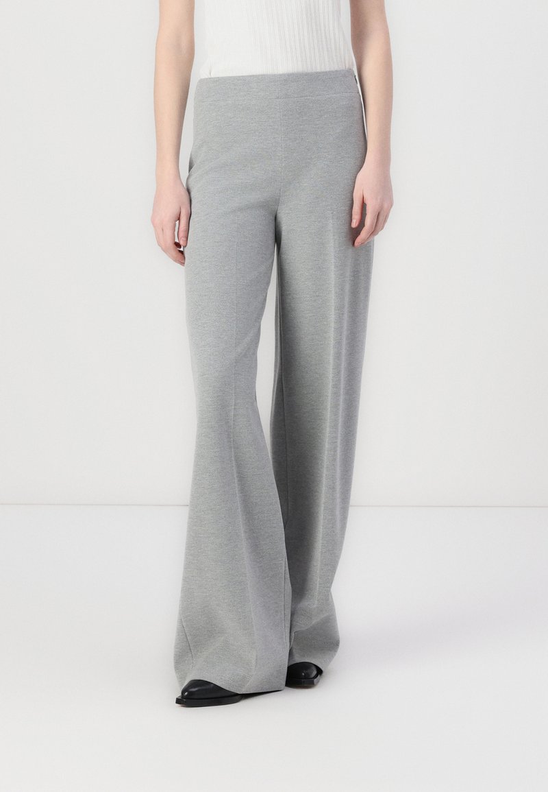 Gray flared trousers made from soft fabric, featuring a wide-leg design and a smooth, stretchy waistband. Black shoes complement the outfit.