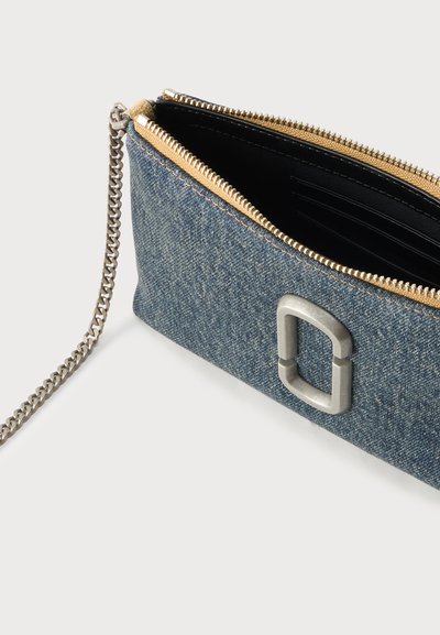 Τσαντάκι χειρός από τζιν με χρυστό φερμουάρ, αλυσίδα ασημί και ορθογώνια ασημένια αγκράφα στο πλάι.