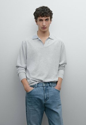 Lichtgrijze lange mouwen polo met een notch kraag en blauwe accenten, gecombineerd met lichtblauwe spijkerbroek. Gladde stof met een comfortabele pasvorm.