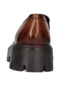 Bruine leren schoen met een gladde afwerking, ronde neus en dikke zwarte platformzool met diepe groeven voor grip.