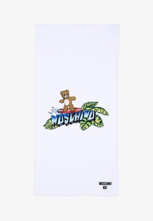 Serviette blanche avec un ours en peluche surfant sur une planche de surf rouge au-dessus du texte "MOSCHINO" et des feuilles tropicales vertes, "MOSCHINO KID" dans le coin inférieur.