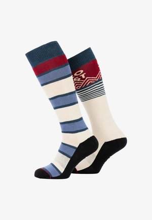 Dryžuoti iki kelių kojinės su mėlynu ir kreminiu raštu, raudonais akcentais ir geometriniu dizainu ant kirtimo. Juodi padai.