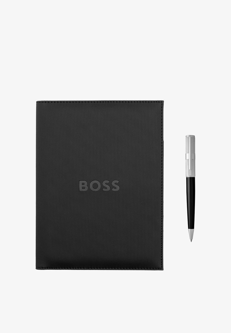 Carnet noir texturé avec le logo "BOSS" en relief, accompagné d'un stylo noir et argent placé à droite, présenté sur fond blanc.
