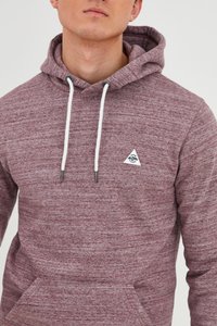 Sudadera burdeos con tejido texturizado, cordones blancos y un logo triangular en el pecho. Cuenta con un bolsillo frontal y un corte relajado.