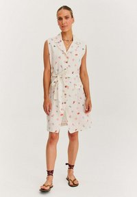 Sukienka bez rękawów w kwiatowy wzór w jasnobeżowym materiale, z kołnierzykiem, guzikami, paskiem w talii i dwiema przednimi kieszeniami.