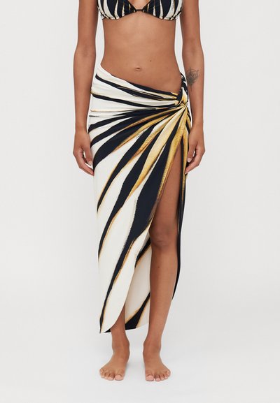 Black and white striped wrap skirt with gold accents, knotted at the waist, featuring a thigh-high slit and lightweight, smooth fabric.