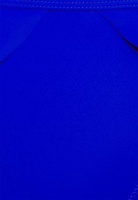 Tecido de fato de banho azul com um acabamento liso e texturizado e um detalhe recortado divertido na parte superior.