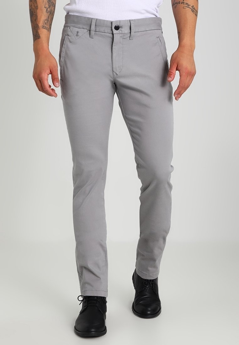 Ljust grå slim-fit byxor med en mjuk textur, utrustade med fickor på sidorna, en knappstängning och en bältesloopad midja.