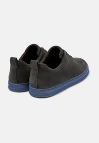 Grijze suède schoenen met een laag profiel ontwerp en een blauwe rubbersole. Beschikt over een gladde textuur en minimale stikseldetails.