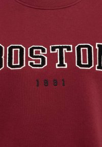 Bordeaux sweatshirt met "BOSTON" in vetgedrukte zwarte letters, met daaronder in kleinere zwarte letters "1991". Gemaakt van zacht katoen en heeft een ronde hals.